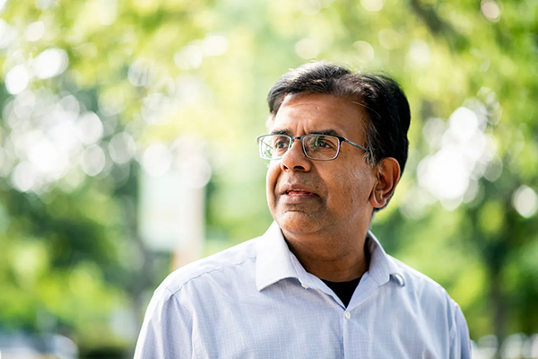 Mansoor Amiji standing outside looking off to the left