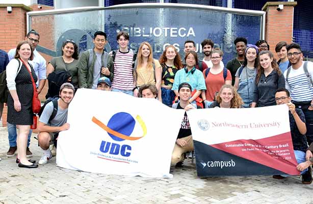 group of students pose with Brazil banner on a group trip in that country.